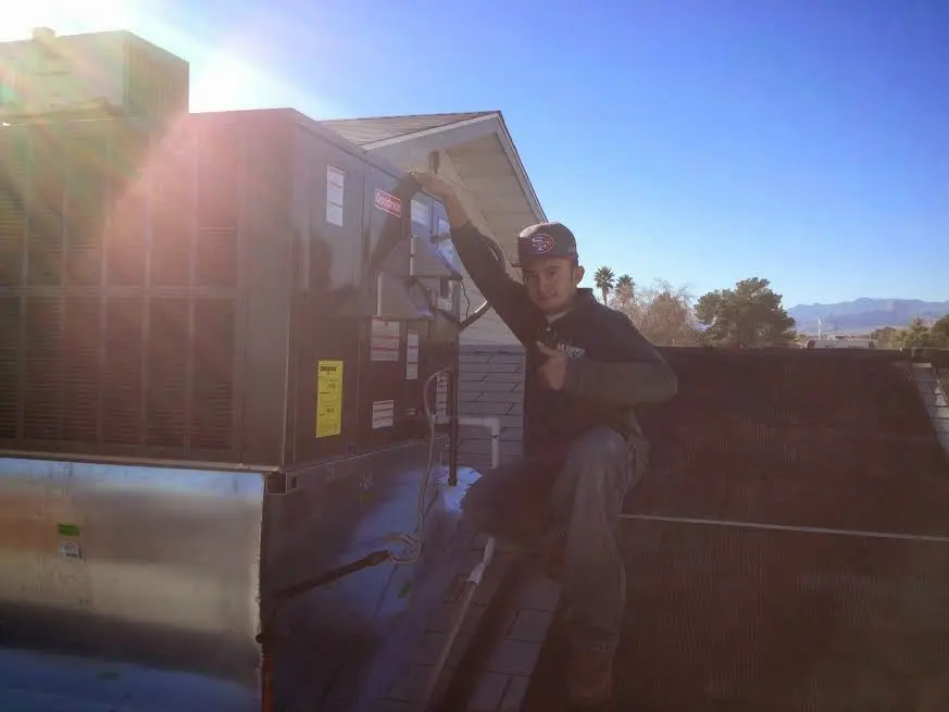 HVAC technician performing Air Duct Cleaning on a rooftop unit in Yreka